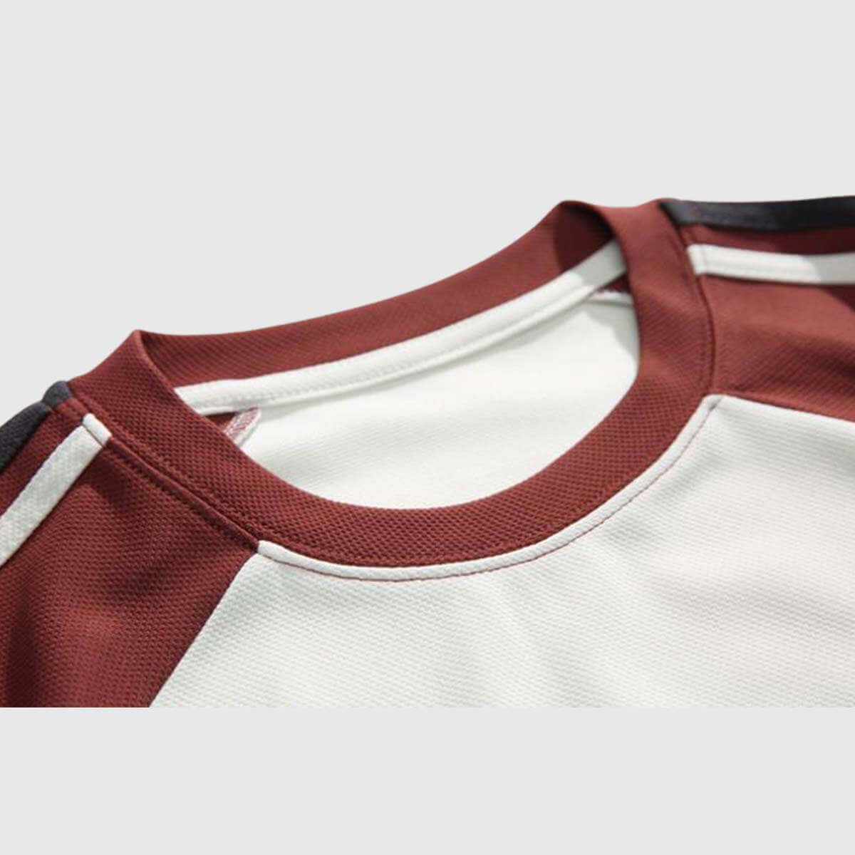 Close-up of a vintage graphic raglan shirt showing the collar and sleeve details in rich maroon and breathable fabric.